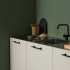 Black kitchen handles in a modern kitchen with smooth light doors and green wall