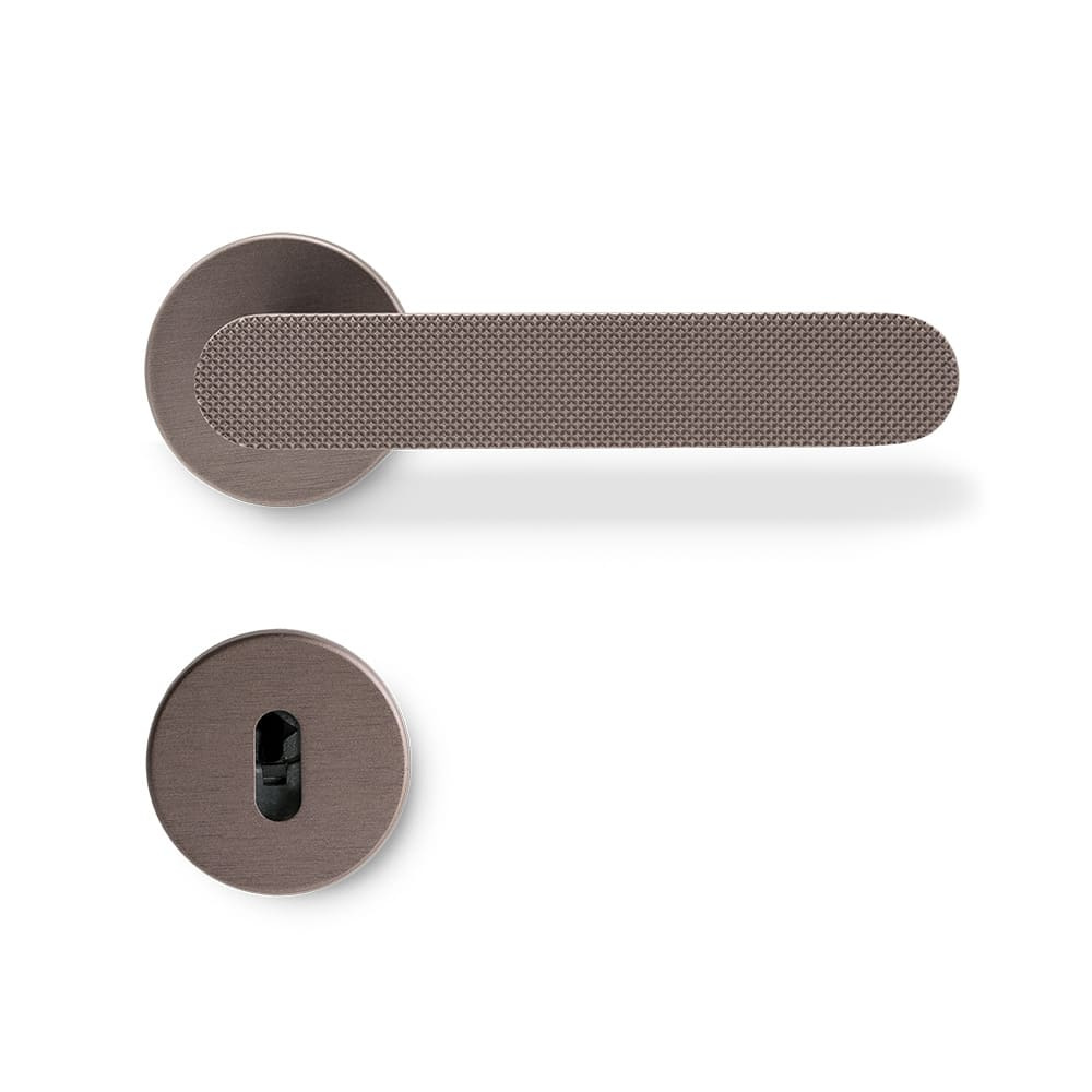 Door handle Vibe Grip with a modern and sleek design in dark bronze. Vibe Grip is elongated and rounded with a knurled surface.
